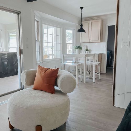 A cozy seating area with a view into the bright and inviting kitchen, featuring a dining nook and stylish decor for a comfortable stay.