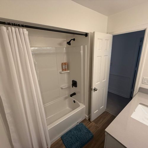 Bathroom 2 features a clean and modern design with a bathtub and shower, a vanity sink, and essential amenities for your stay.