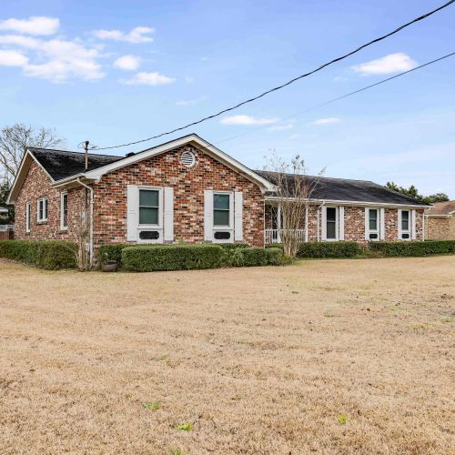 The exterior of the property boasts a classic brick design and a spacious yard, offering plenty of room to relax and enjoy the surroundings.