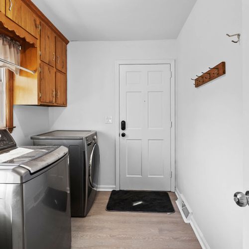 The laundry room is equipped with a washer and dryer for your convenience, along with storage cabinets and a private entrance for easy access.