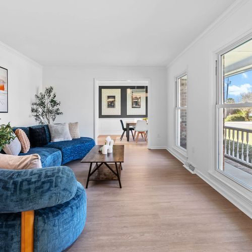 Bright and inviting living space with chic decor, vibrant seating, and plenty of natural light—ideal for relaxing or entertaining!
