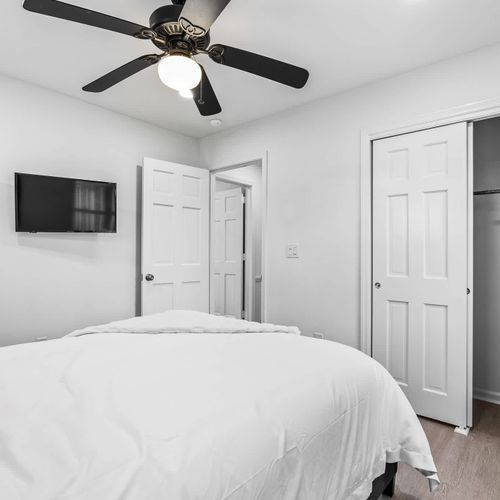 Comfortable bedroom with a cozy bed, ample closet space, and a mounted TV — perfect for relaxing after a day of exploring.