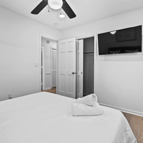 Unwind in this serene bedroom with a sleek TV, ample closet space, and a cozy ambiance for ultimate comfort.
