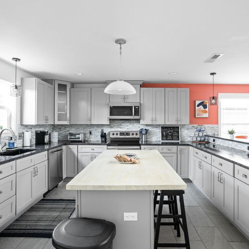 Kitchen: Bright and modern space with sleek granite counters and stylish light fixtures!