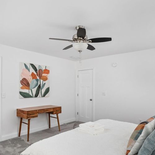 Primary Bedroom: Bright and inviting space with plush bedding, a stylish desk, and vibrant decor!