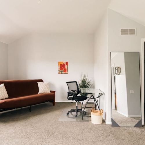 Primary bedroom with extra seating and a desk