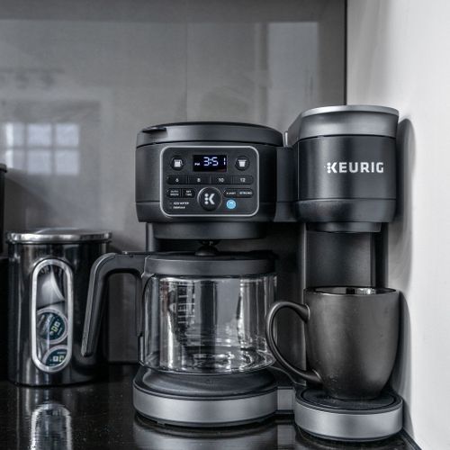 Keurig with pods and ground coffee, plus sugar, stevia, creamers—and a kettle with tea packets for the tea lovers!