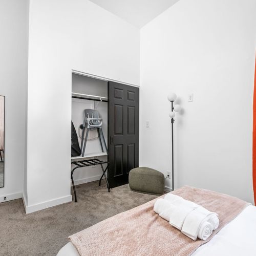 A full-length mirror, footstool, and modern lamp complete the space—plus a high chair and Pack ’n Play for the little ones!