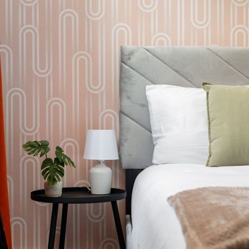 Nightstand goals—funky wallpaper, soft lighting, and a touch of green.