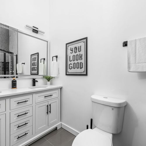 Primary ensuite bathroom with a modern double vanity, smart mirror, and a daily dose of confidence — you look good!