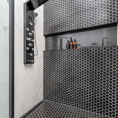 Walk-in shower goals—classic black & white hex tile paired with a high-tech shower head and our essentials for the ultimate refresh.