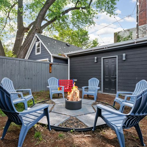 Kick back in the backyard by the modern stainless steel fire pit, blue chairs, games, and grill—outdoor vibes done right, plus easy access to the one-car garage!