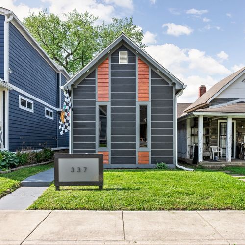 Modern vibes from the curb — dark siding, wood accents, and a bold house number that makes a statement, can’t forget our Indianapolis Motor Speedway flag!