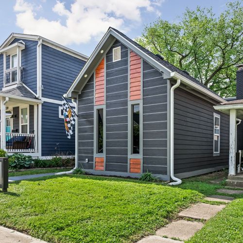 Modern vibes from the curb — dark siding, wood accents, and a bold house number that makes a statement, can’t forget our Indianapolis Motor Speedway flag!