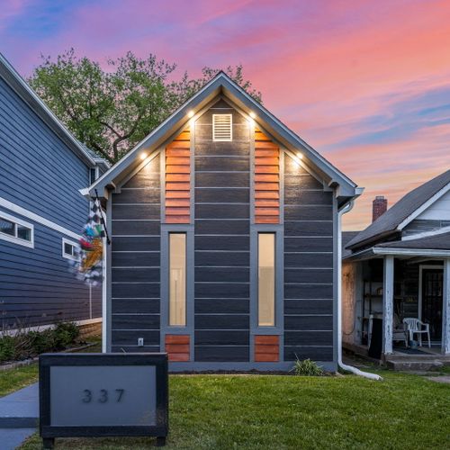 Modern vibes from the curb — dark siding, wood accents, and a bold house number that makes a statement, can’t forget our Indianapolis Motor Speedway flag!