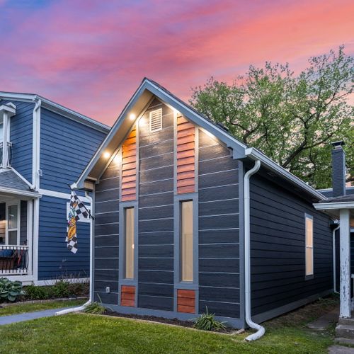Modern vibes from the curb — dark siding, wood accents, and a bold house number that makes a statement, can’t forget our Indianapolis Motor Speedway flag!