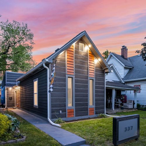 Modern vibes from the curb — dark siding, wood accents, and a bold house number that makes a statement, can’t forget our Indianapolis Motor Speedway flag!