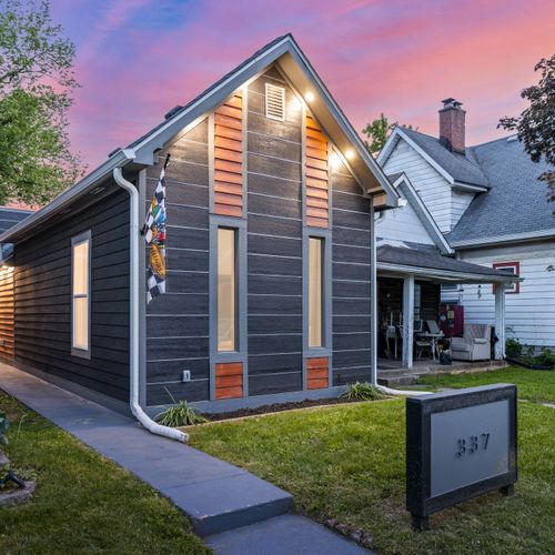 Modern vibes from the curb — dark siding, wood accents, and a bold house number that makes a statement, can’t forget our Indianapolis Motor Speedway flag!