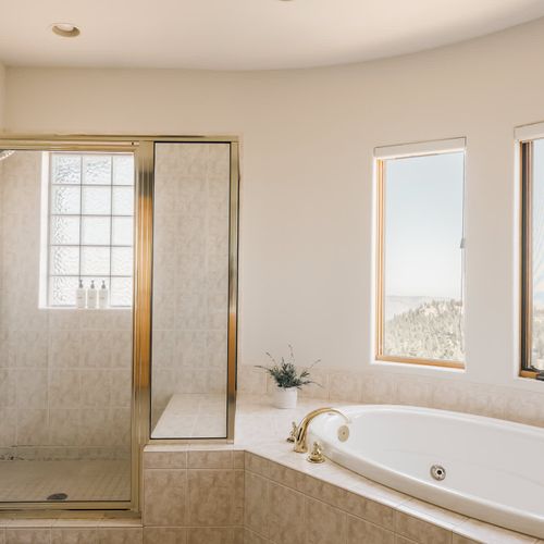 Walk-in glass shower and soaking tub in the primary bathroom