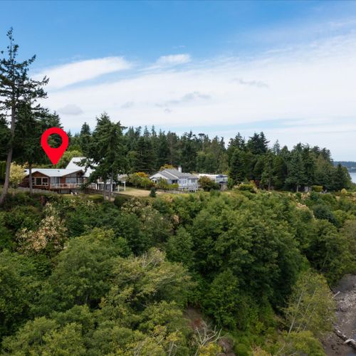 The home sits on a bluff above the Sound,. The beach is right below, access is a few minutes walk away.