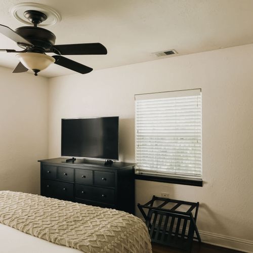 Bedroom 1 has a ceiling fan and TV