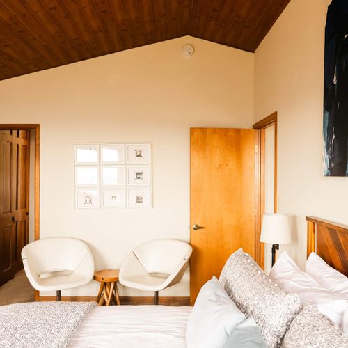 Primary bedroom with king bed, seating area, and full, private, ensuite bathroom