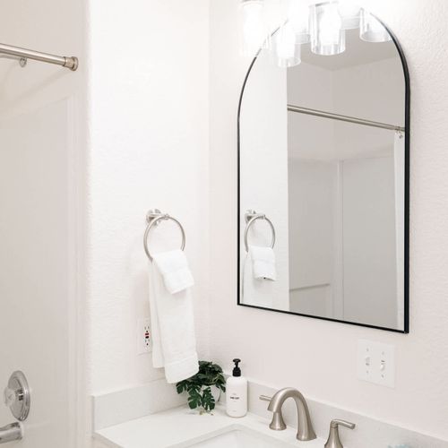 Primary bedroom's full & private ensuite bathroom with dual vanities and a tub/shower combo