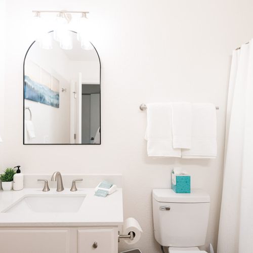 Primary bedroom's full and private ensuite bathroom with dual vanities and a tub/shower combo