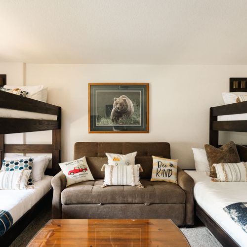 Bunk room with a twin over twin bunk, twin over queen bunk, and a queen-size sleeper sofa