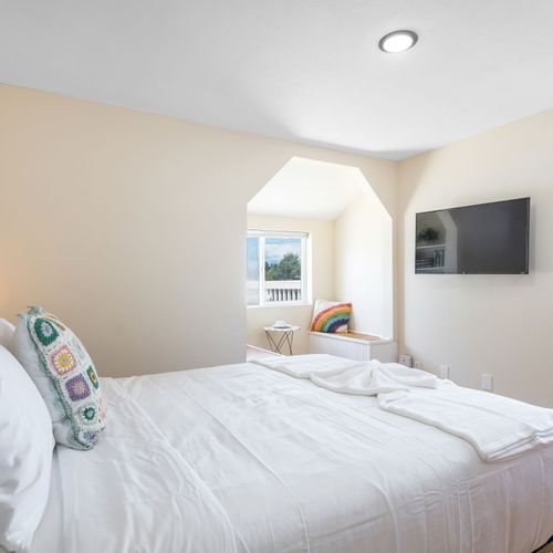 Primary bedroom with bright windows and cozy nook.