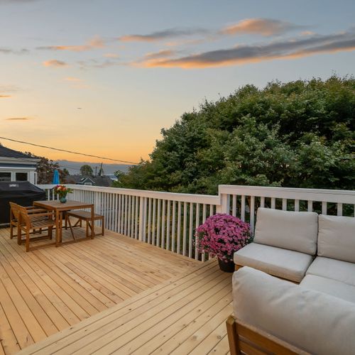 Upper deck with outdoor sofa and sunset views — the perfect place for wine and conversation.