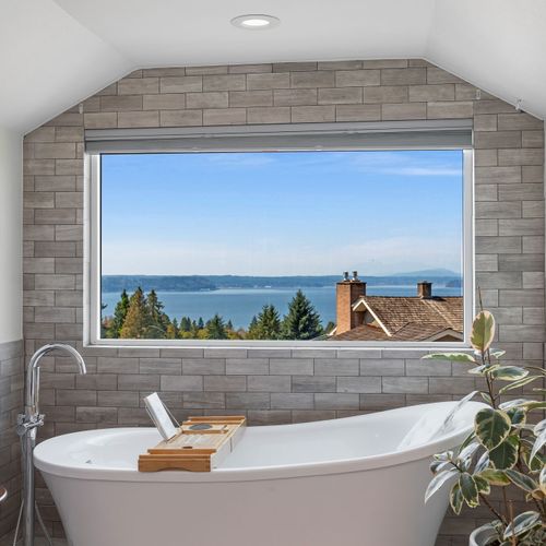 Soak in pure bliss—unwind in a luxurious tub with serene views through a picture-perfect window.