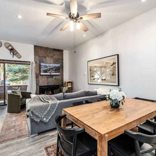 Dining area and living area with patio access, flat-screen TV, and sleeper sofa (the wood-burning fireplace is not an advertised amenity)