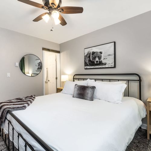 Primary bedroom with king bed, flat-screen TV, and a full, private ensuite bathroom.