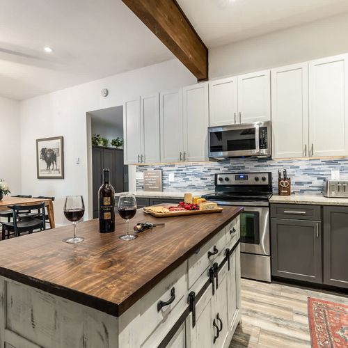 Open kitchen with island seating and dining table (charcuterie board and wine, not included)