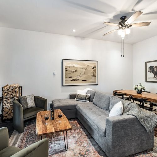 Living area with flatscreen TV, full-size sleeper sofa, and dining table (the wood-burning fireplace is not an advertised amenity)