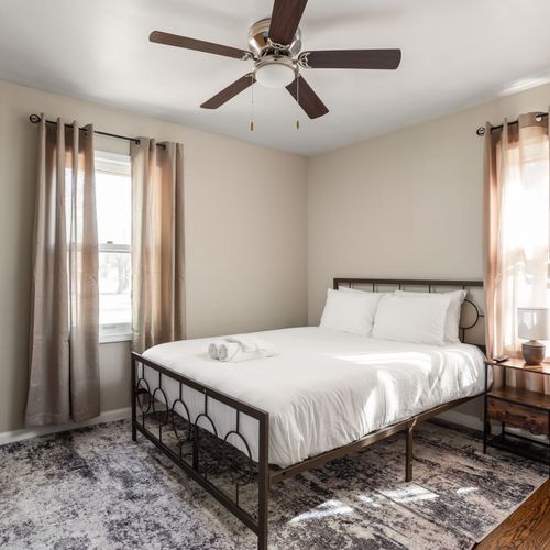Queen Bed with a TV, premium linens, and warm decor.