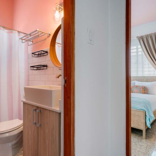 modern bathroom with large mirror, shower curtains, towels, white sink with stainless steel faucet, WC