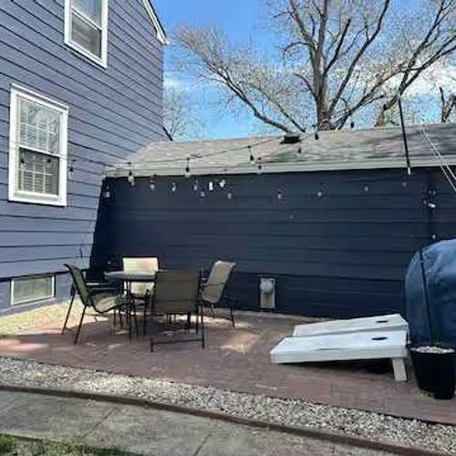 Backyard with outdoor seating, corn hole, a grill, and lights!