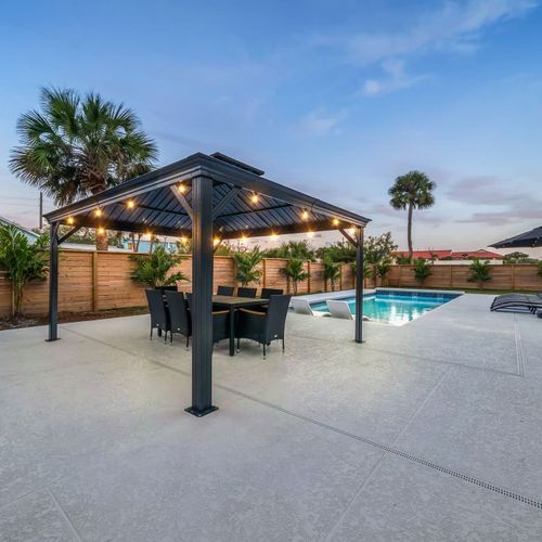 Backyard patio with covered pergola, outdoor dining area, and private pool.