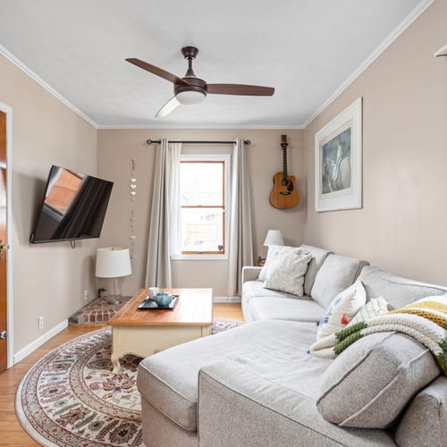 Cozy second living space with a smart TV, ceiling fan, and comfy sectional — ideal for movie nights!