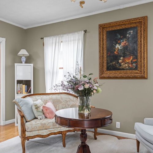 Elegant seating area featuring antique accents, fresh florals, and stunning natural light.