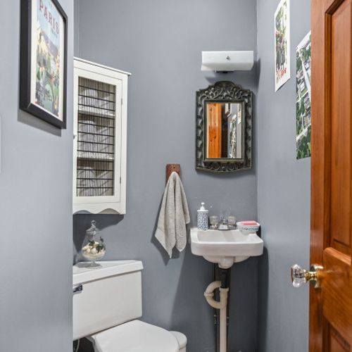 Convenient main-level powder room with vintage charm and stylish black-and-white tile floors.
