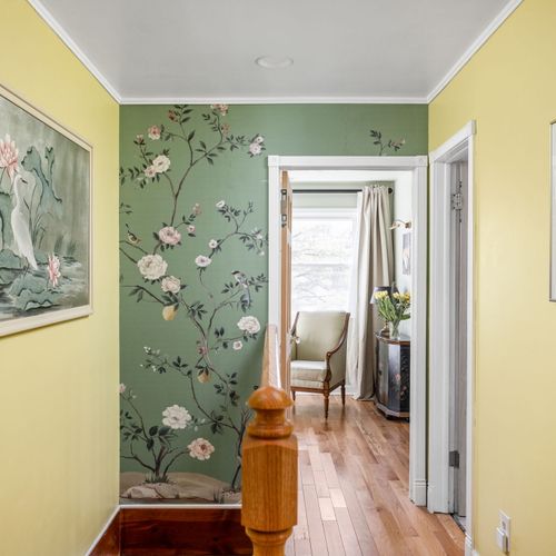 Stunning hand-painted floral mural and original artwork bring artistic flair to the upstairs landing.