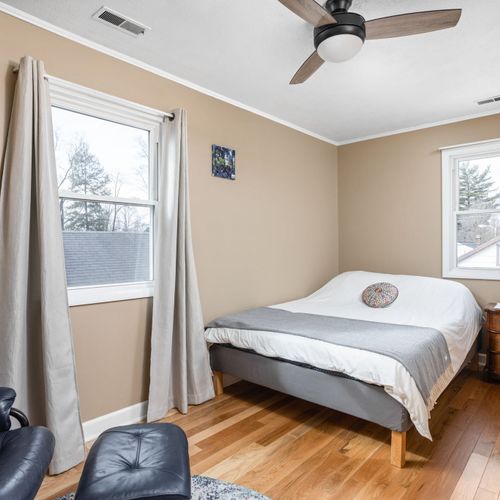 Bedroom 2 features a cozy queen bed, beautiful hardwood floors, and plenty of natural light.