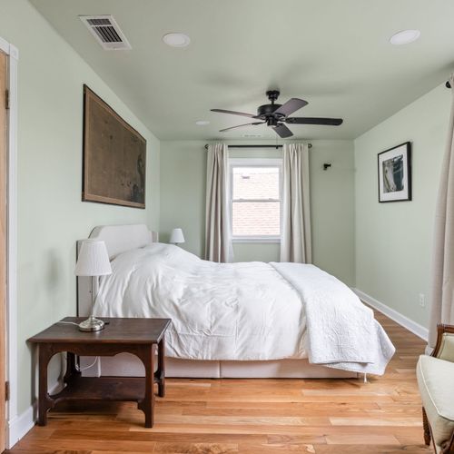 Primary Suite featuring a cozy king bed, soft natural light, and elegant historic touches.