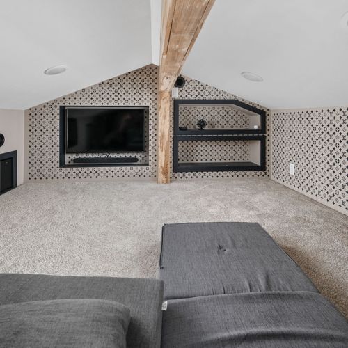 Welcome to the hideaway — a designer-inspired escape tucked away just for you, complete with a smart TV, built-in shelving, and plush floor seating for the ultimate lounge session.