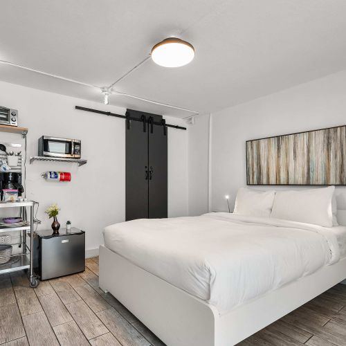 Wake up refreshed in a pristine double bed. Features stylish matte-black barn doors and minimalist design perfect for couples and digital nomads.