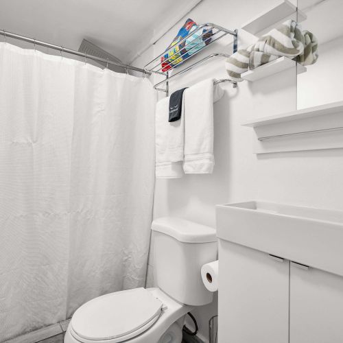 Slide open the architectural barn doors to reveal a clean, modern en-suite bathroom. Seamless privacy just steps from your bed.