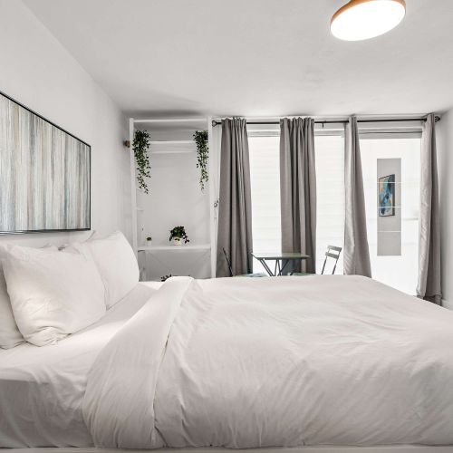Unwind in a sleek, open-concept studio. Enjoy a plush queen bed right next to your private, fully equipped kitchenette—perfect for seamless urban living.